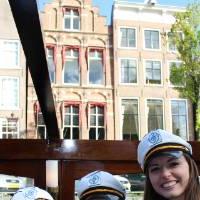 three global lakers smile in captains hats on boat